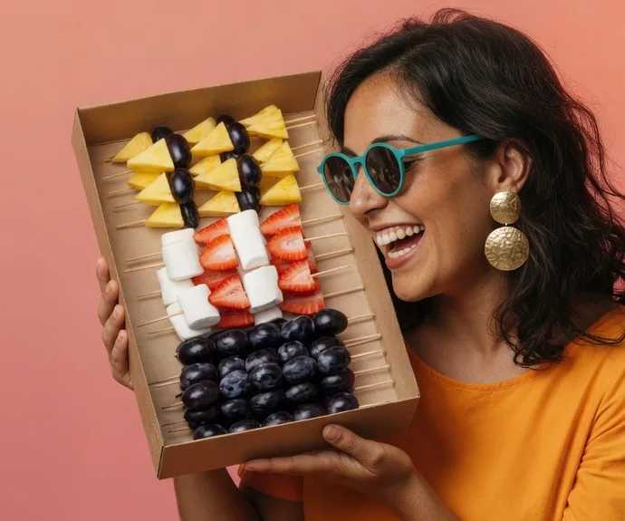 Ilustración de la marca: anfitriona con una caja de brochetas de fruta