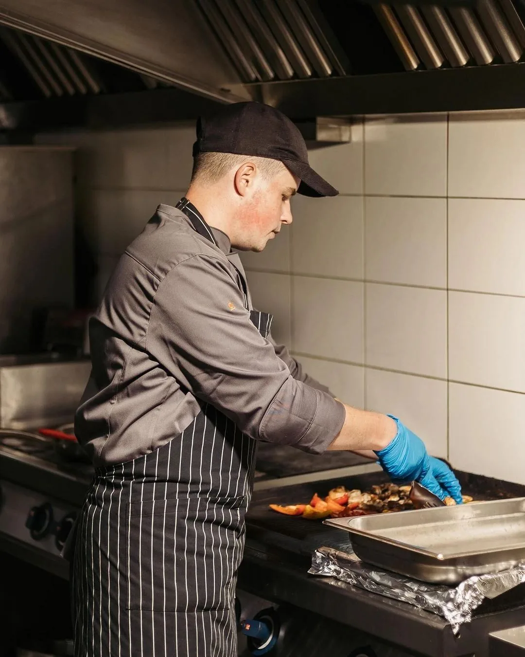 Cocinero emplatando junto a la plancha